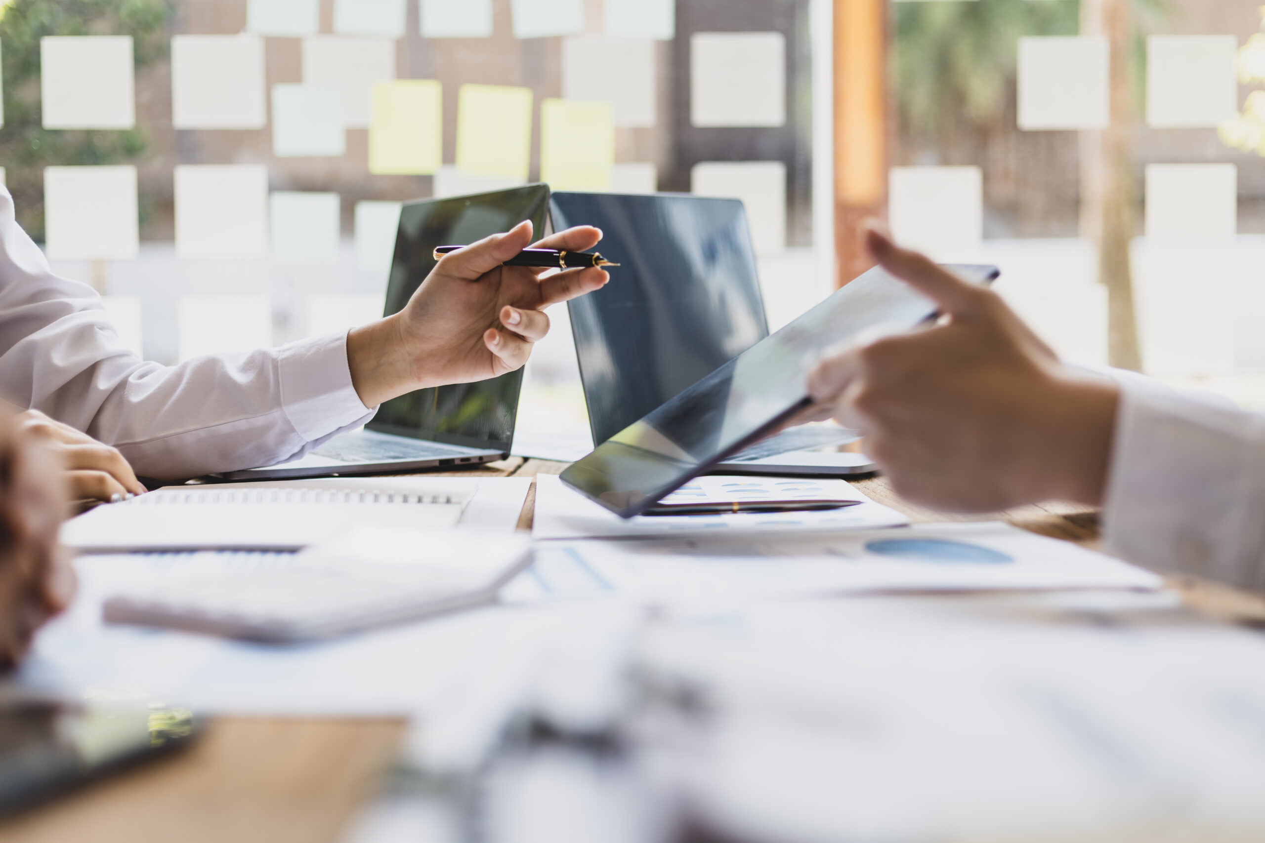 Business meeting, brainstorming sessions discuss analysis of investment growth graph and market charts in financial reports and business investment strategy planning.
